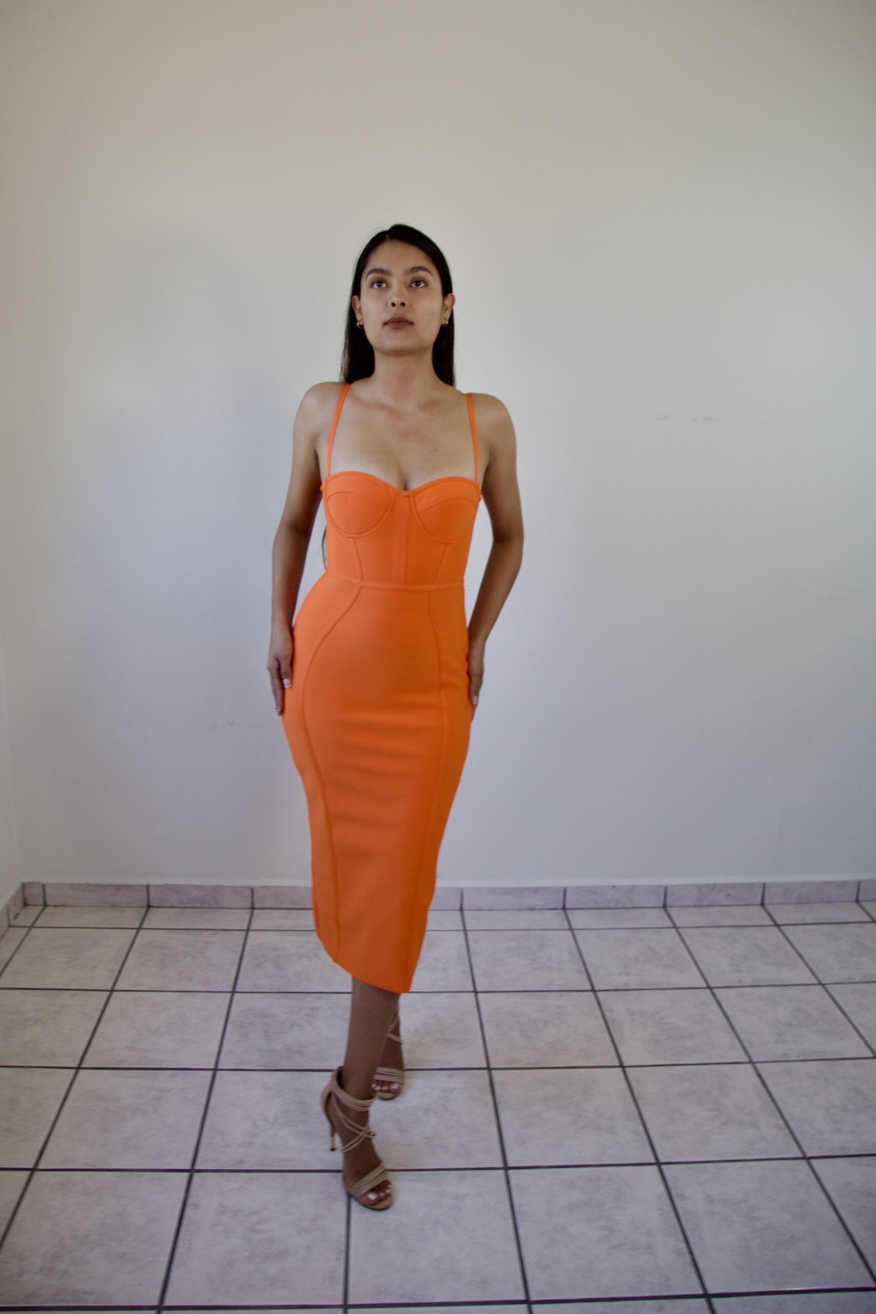 Model Karina Araujo in a women's orange midi dress