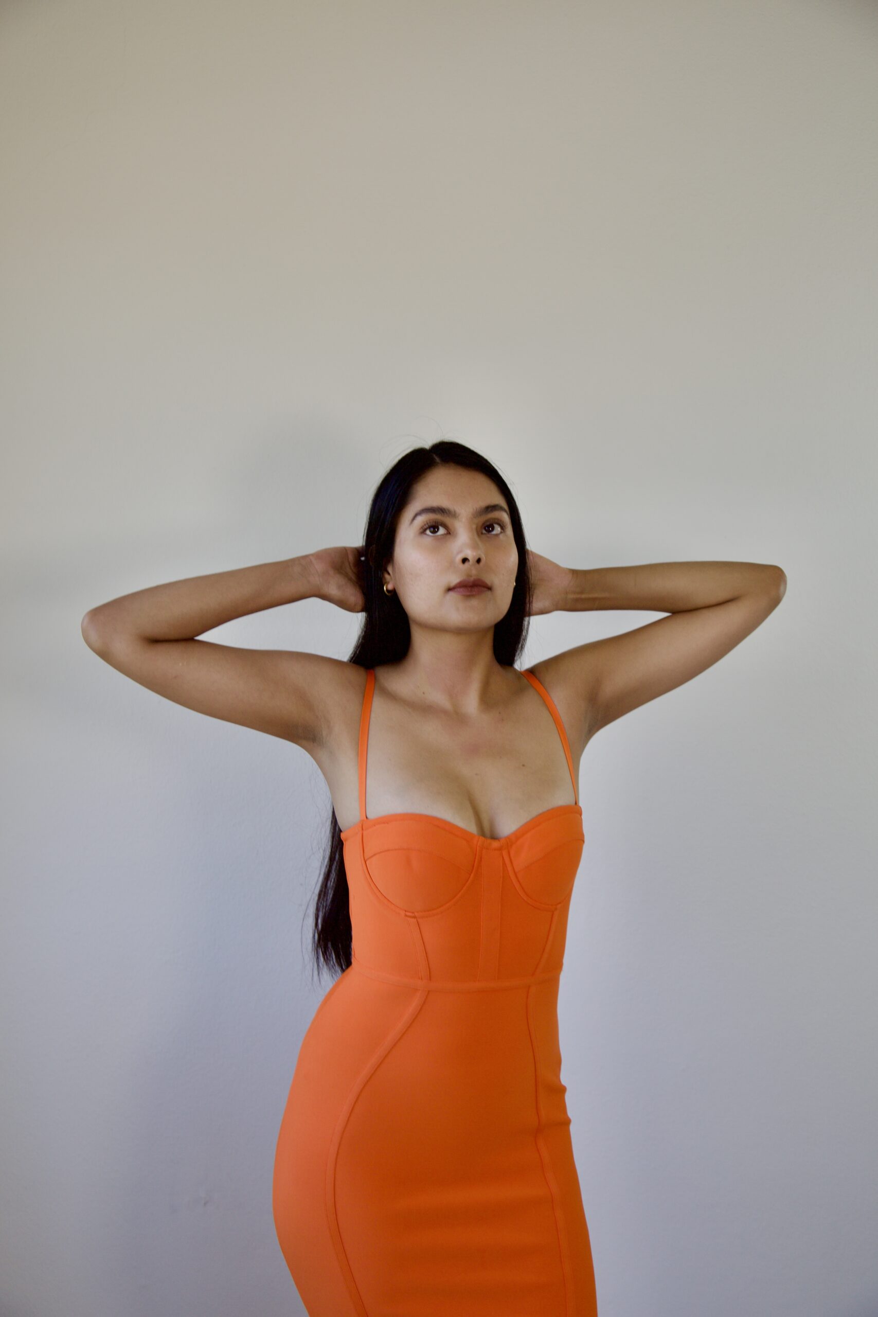 Model Karina Araujo in a women's orange midi dress