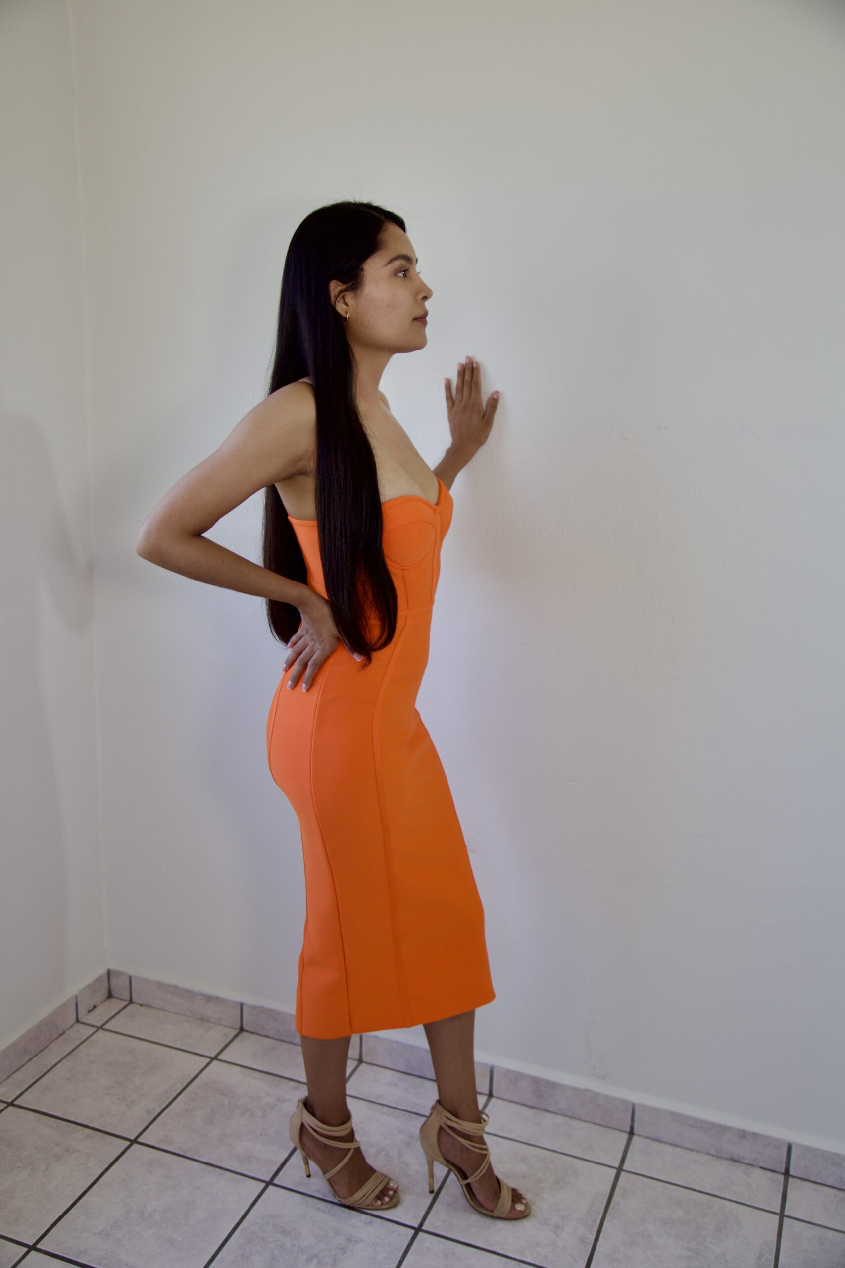 Model Karina Araujo in a women's orange midi dress