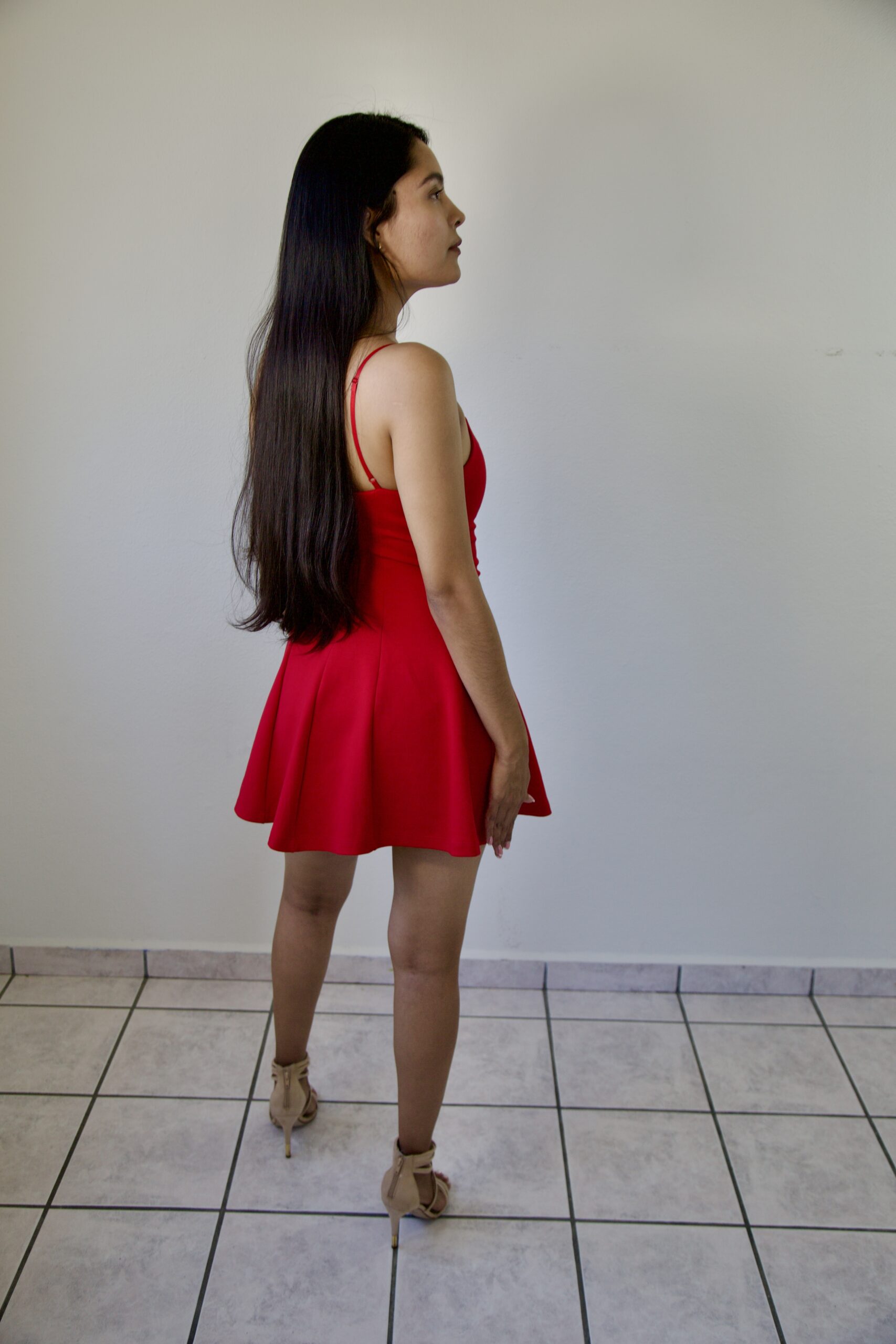 Model Karina Araujo wearing a short red women's dress.