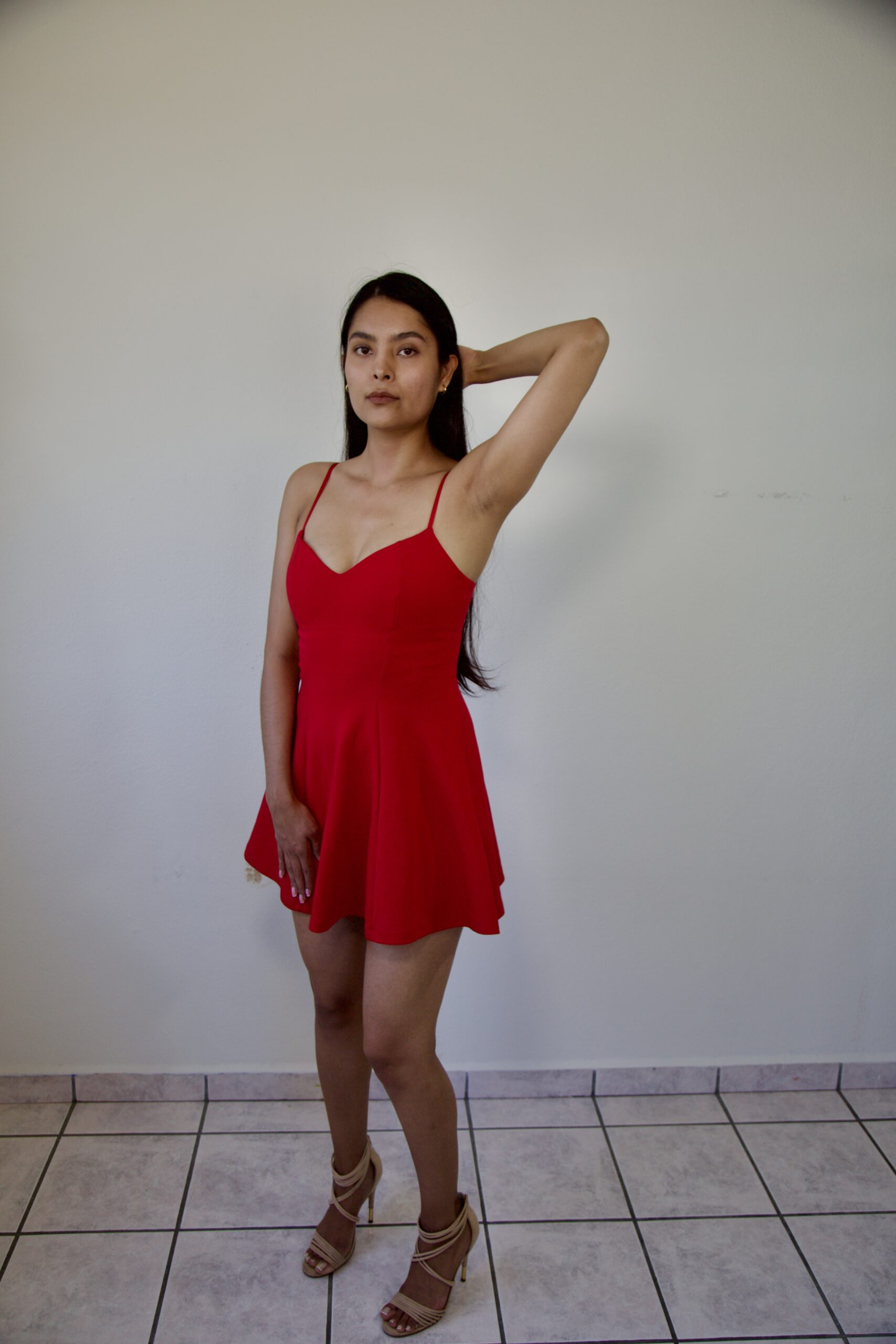 Model Karina Araujo wearing a short red women's dress.