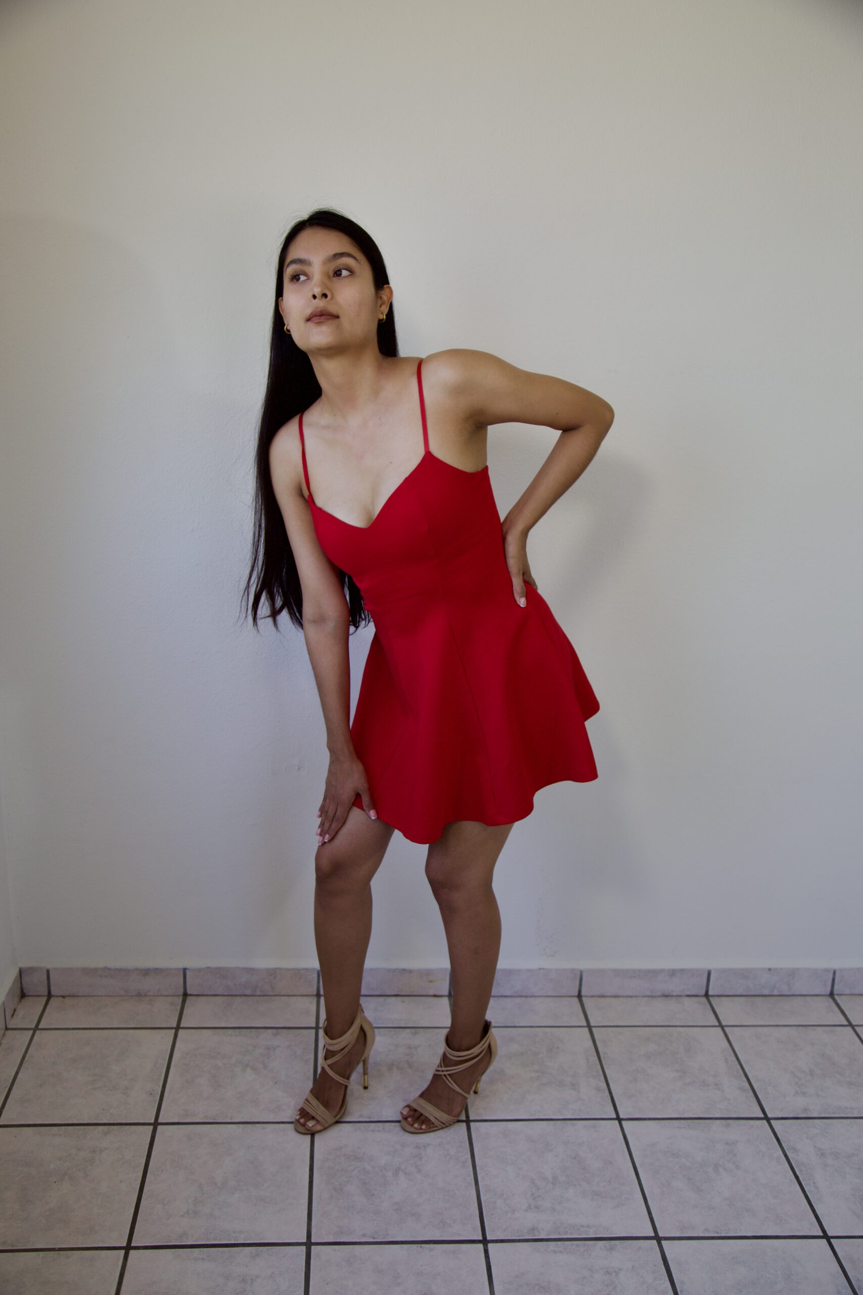 Model Karina Araujo wearing a short red women's dress.